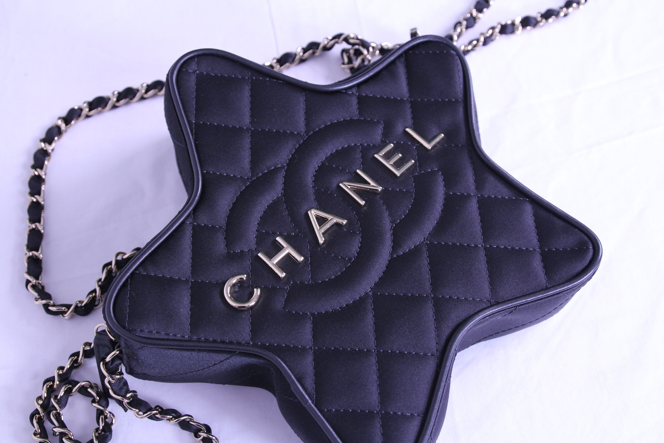 Front of Chanel star handbag in finished in black satin