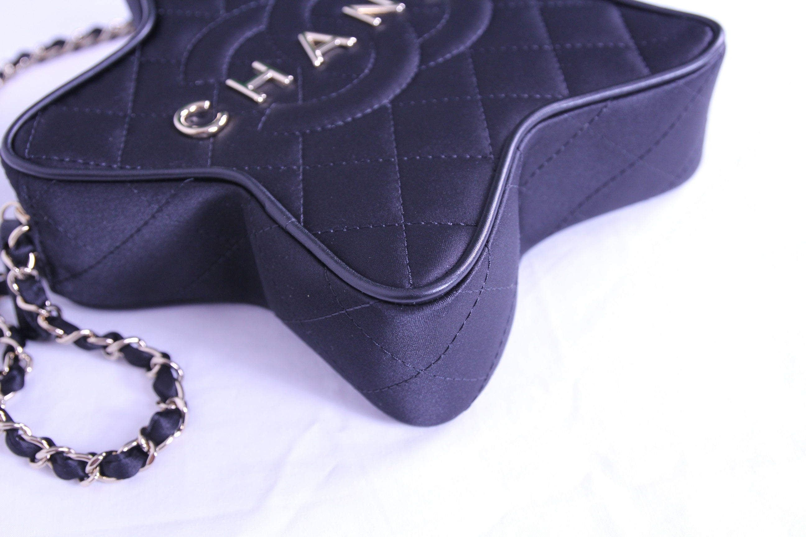 Corner of Chanel star handbag in finished in black satin