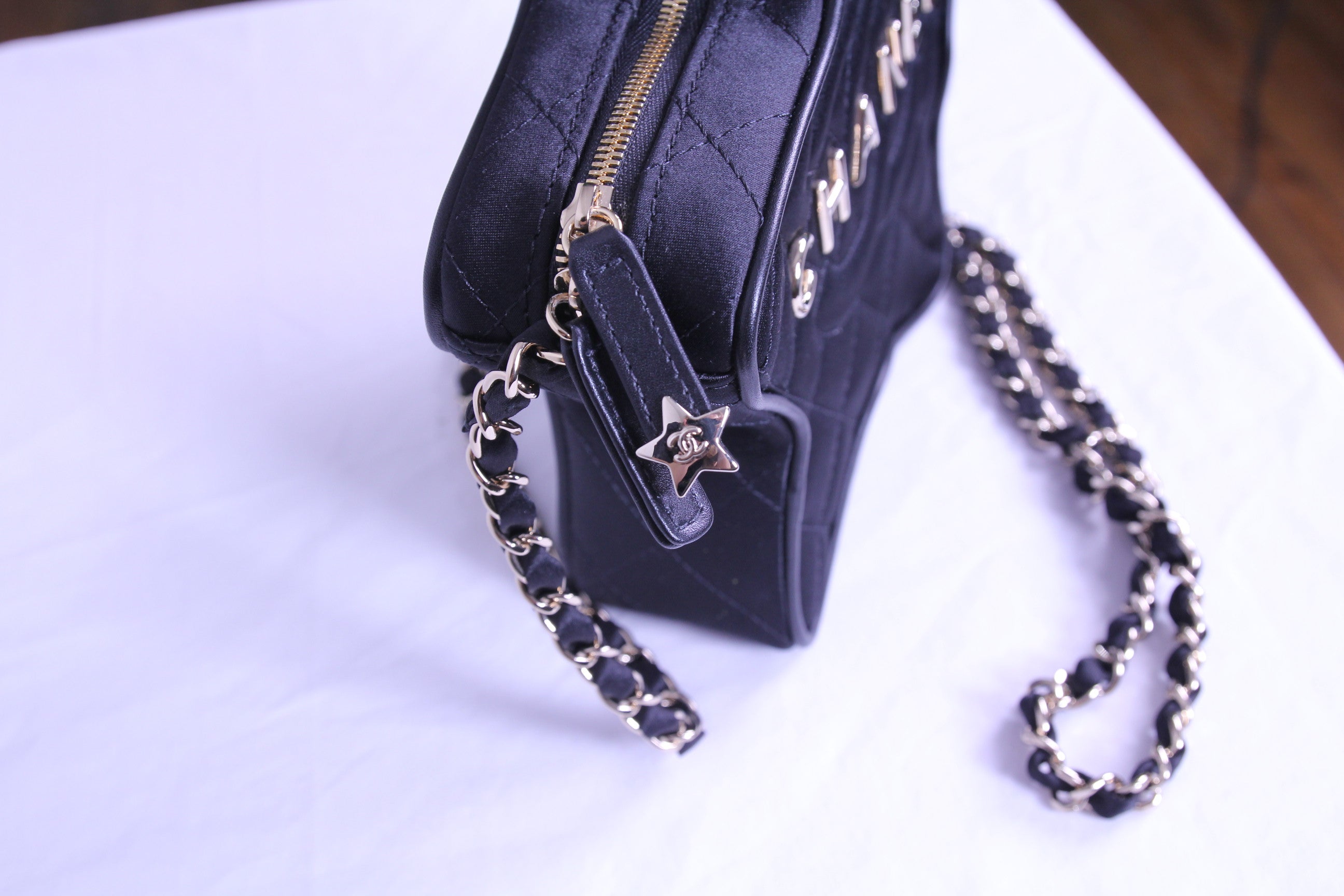 Zipper of Chanel star handbag in finished in black satin