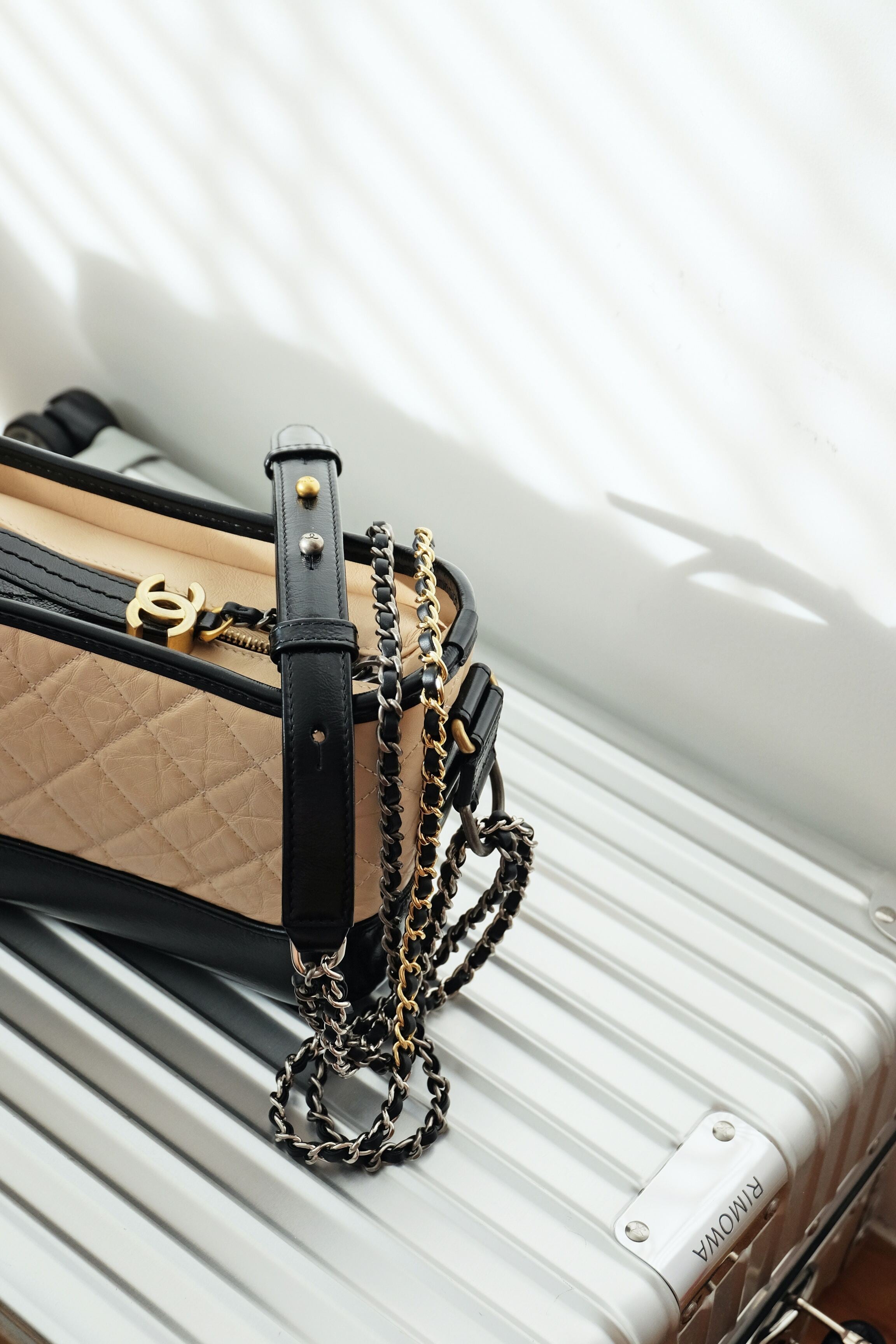 Chanel Beige and Black Gabrielle Bag places on a Rimowa Suitcase 